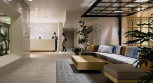 a living room with a couch and a person in the background at Hotel Edit Yokohama in Yokohama