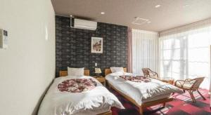 a bedroom with two beds in a room with a window at Fuji Shoei kaikan in Sukawa