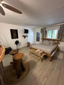 a bedroom with a bed and wooden floors and windows at Studio avec jardin et piscine in Saint-François