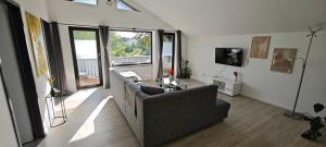 a living room with a couch and a tv at Villa Levilia in Strullendorf
