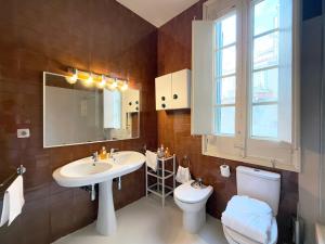 une salle de bain avec un lavabo, des toilettes et un miroir dans l'établissement Ca La Manso, à Sitges