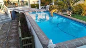 a swimming pool with blue water in a backyard at Lily's Lodge in Somerset West