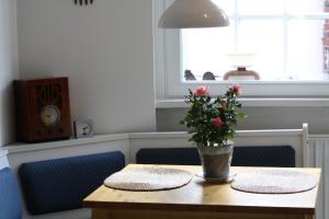a wooden table with a vase of flowers on it at Ferienwohnung Am Mittelburgwall in Friedrichstadt