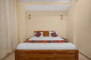 a bedroom with a bed with a wooden frame at FabHotel Marine - Vishnu Temple Bada Lalpur in Varanasi