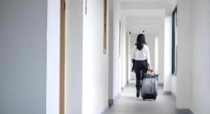 una mujer caminando por un pasillo con una maleta en Meesuk ChiangRai Hotel, en Chiang Rai