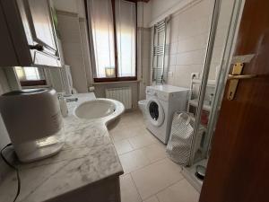 a bathroom with a sink and a washing machine at Casa del Mare in Marotta