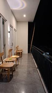 Zimmer mit Tischen und Bänken auf einem Balkon in der Unterkunft Fan Family Bromo Homestay in Ngadisari
