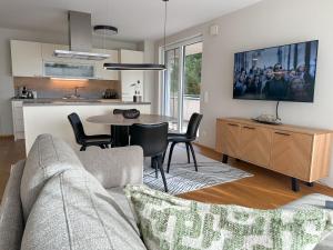 a living room with a couch and a table in a kitchen at "FOUR" - Premium Apartments Seekirchen, Stilvolle 3-Zimmer Wohnung mit Balkon in Größing