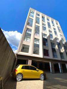 une voiture jaune garée devant un bâtiment dans l'établissement Stay With Moraa, à Ongata Rongai  14 autres photos