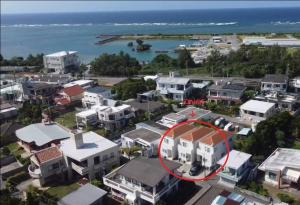 eine Luftaufnahme einer Stadt mit einem weißen Haus mit einem roten Kreis in der Unterkunft Grandioso OKINAWA VILLA ONNA 5A - Vacation STAY 97721 in Meta