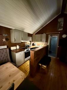 une cuisine avec des armoires blanches et un plancher en bois dans l'établissement Utibakken - cabin ski inn-out Norefjell, à Surteberg
