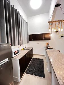 a kitchen with stainless steel appliances and a counter top at Cozy studio AlJimi in Al Ain