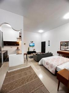 a bedroom with a bed and a living room at Cozy studio AlJimi in Al Ain