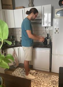 a man standing in a kitchen with a tea pot at Chez Jigé - Bel appartement à côté de l'Adour in Bayonne +9 photos