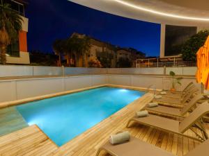 a swimming pool with two lounge chairs and a swimming pool at Echinus Blue Hotel in Antalya