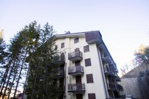 ein weißes Apartmenthaus mit Balkonen und Bäumen in der Unterkunft La Dimora San Rocco, Montagna e Relax in Roccaraso