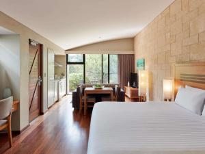 ダンズボローにあるプルマン バンカー ベイ リゾート マーガレット リバーのベッドとダイニングルームがあるホテルの部屋