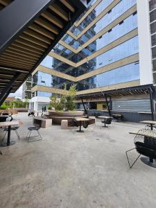 ein großes Gebäude mit Tischen und Stühlen im Innenhof in der Unterkunft Brand New Luxury South Tower Artemisa District in Tegucigalpa