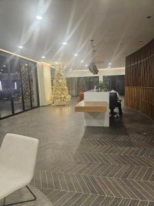 eine Lobby mit einem Weihnachtsbaum, einem Tisch und Stühlen in der Unterkunft Brand New Luxury South Tower Artemisa District in Tegucigalpa + 141 Fotos