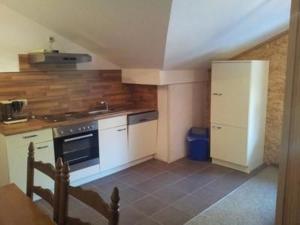 a kitchen with white cabinets and a white refrigerator at Reiterstübchen in Kuchelmiß