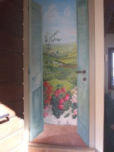 una puerta abierta con una pintura de flores en la pared en Casa Verde, en San Michele in Teverina
