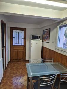 ein Wohnzimmer mit einem Tisch und einem Kühlschrank in der Unterkunft Charmant studio centre village in Gréoux-les-Bains