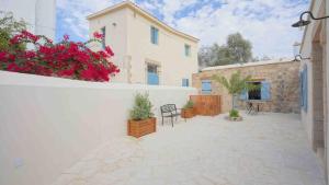 a patio with chairs and flowers in a building at stonebuilt HiddenHouse in Paphos