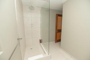 een badkamer met een glazen douche met toilet bij Cyprus Seas in Gqeberha +28 foto's