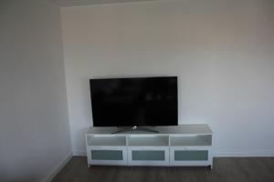 a flat screen tv sitting on top of a white entertainment center at Ferienwohnung am Kreuzfelsen in Bestwig