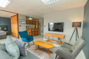 een woonkamer met een bank, een tafel en stoelen bij Cyprus Seas in Gqeberha