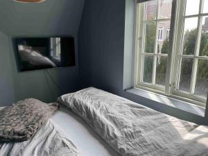 an unmade bed in a bedroom with a window at Central Apartment Stavanger 2 Bedroom Sleeps 4 in Stavanger