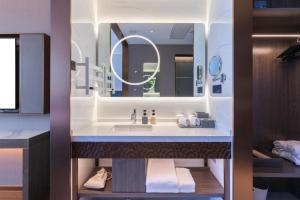 a bathroom with a sink and a mirror at Langliz Hotel Capital Airport New International Exhibition Center Branch in Beijing +4 photos