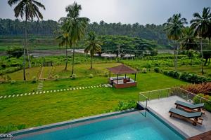 博拉吉Pollachi Riverhouse, A CGH Earth Saha experience的一个带游泳池和公园的度假胜地