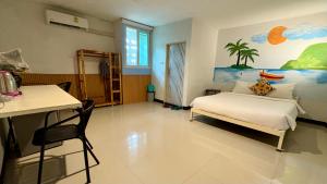 a bedroom with a bed and a painting on the wall at WAKE UP @Lanta Hotel : Cafe in Ko Lanta