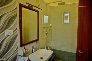 un baño con lavabo y espejo en Pollachi Riverhouse, A CGH Earth Saha experience, en Pollachi