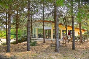 a house in the middle of a forest of trees at Camping Cristal d'Opale in Camiers