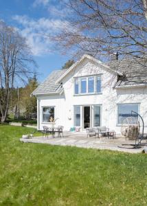 ein weißes Haus mit einer Terrasse mit Tischen und Stühlen in der Unterkunft Lovely sea view in modern family house! in Steinkjer