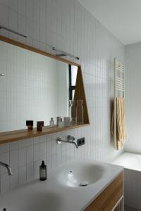 un baño con lavabo y espejo en Canopée guesthouse, en Bruselas 54 fotos más