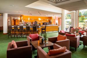 a restaurant with brown chairs and a bar at Vivea Hotel Bad Goisern in Bad Goisern