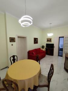 un salon avec une table et un canapé rouge dans l'établissement Villa Mehari, à Pise