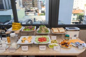 a buffet of food on a table with plates of food at A25 Hotel - 35 Mạc Thị Bưởi in Ho Chi Minh City +50 photos