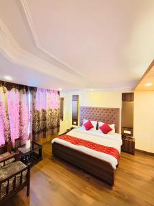 a bedroom with a large bed with red pillows at Lords Grey near Mall Road in Shimla
