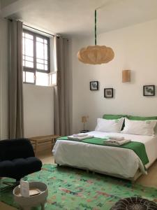 梅克内斯里亚德亚姆查旅馆的一间卧室，里面有一张床、一把椅子和一扇窗户