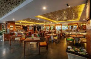 a dining room with tables and chairs in a restaurant at Hotel Radhe in New Delhi