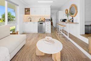 ein Wohnzimmer mit einer weißen Couch und einem Tisch in der Unterkunft Salt & Sky - Luxe Coastal Getaway in Coffs Harbour