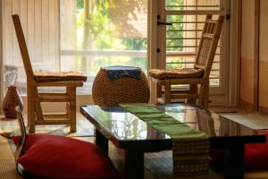a living room with chairs and a glass table at Rurika in Izu +33 photos