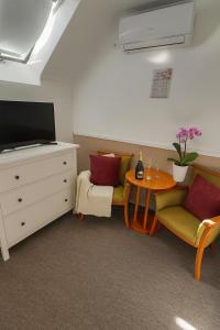 a living room with a tv and a table and chairs at Amfora Panzió in Gyula