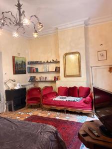 a living room with a red couch and a mirror at Bartissol et Maillol in Perpignan +6 photos