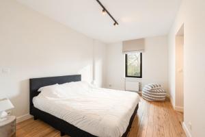 a white bedroom with a bed and a window at exceptional luxury villa near Knokke Golf in Knokke-Heist +18 photos