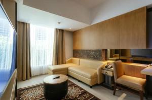 a living room with a couch and a television at Hotel Radhe in New Delhi